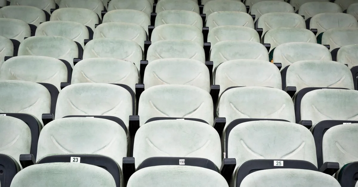 Rangs de sièges blancs vides dans un cinéma, parfaits pour des concepts comme la solitude ou des configurations de séminaire.