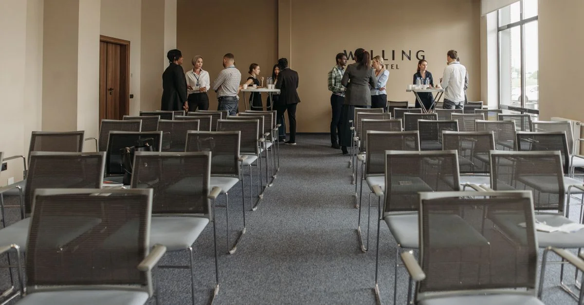Professionnels du secteur des affaires réseautant dans un cadre de salle de conférence.