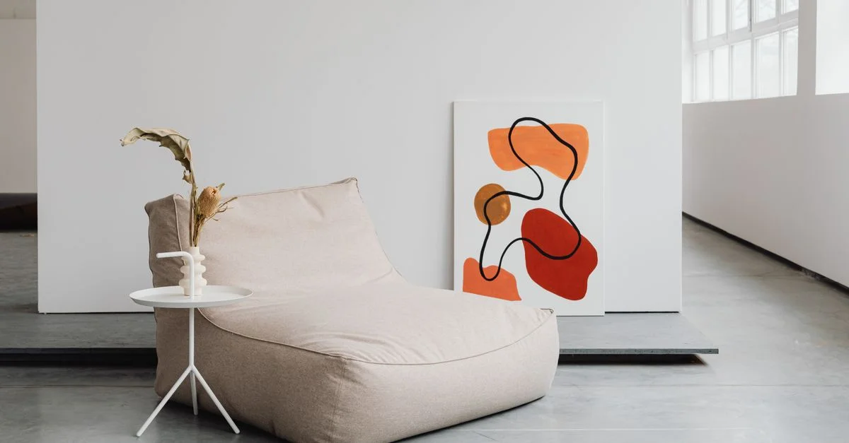 Salon moderne avec peinture abstraite et assises confortables dans un style minimaliste.