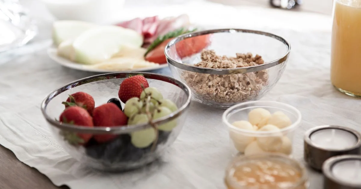 Un délicieux et nutritif petit-déjeuner avec des fruits frais, du granola et du jus sur une table à manger.