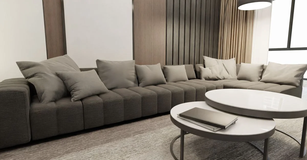 Salon douillet avec un grand canapé gris et des tables rondes élégantes au design scandinave.